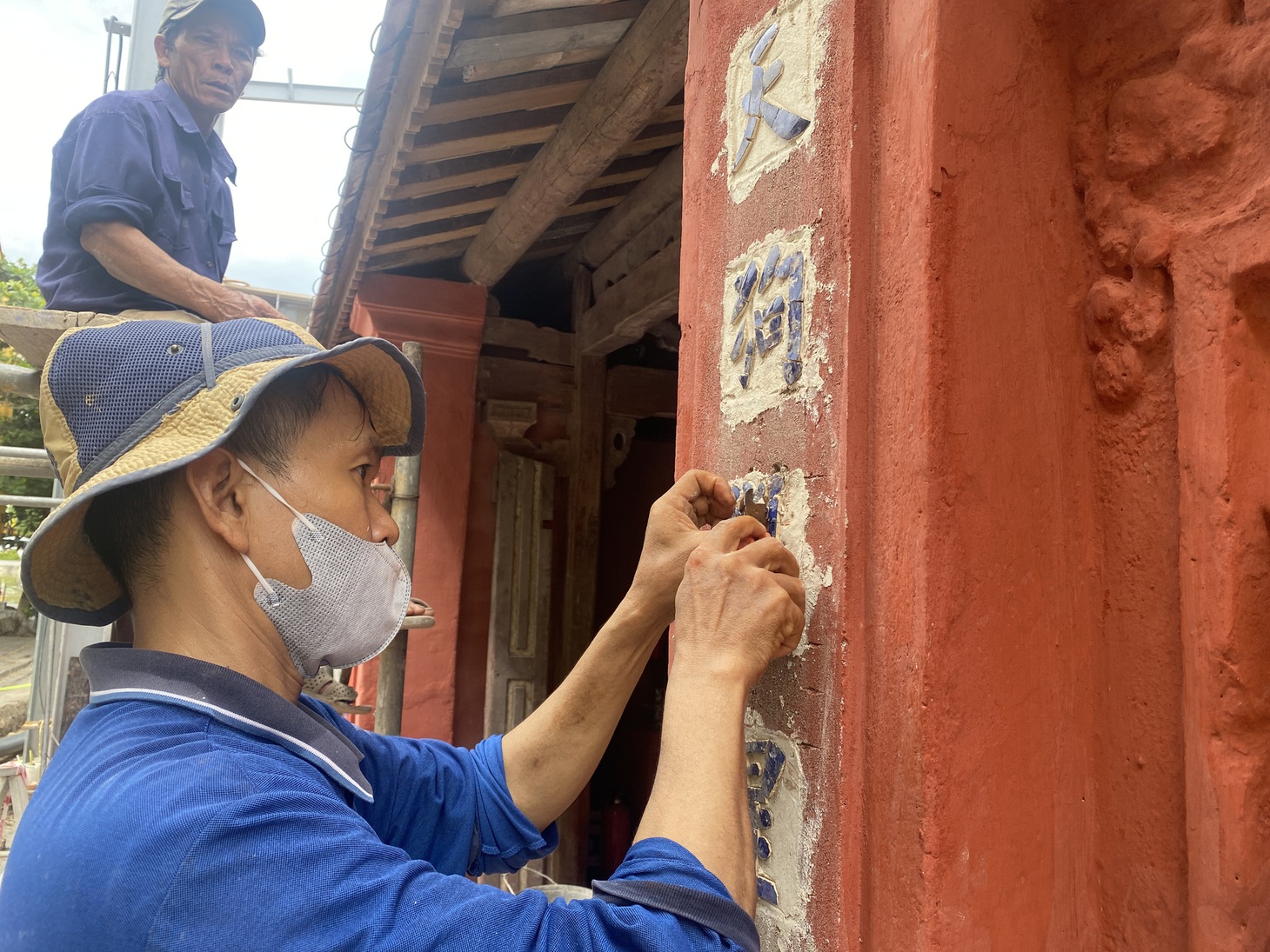 Người thợ đắp dán từng chi tiết trong quá trình trùng tu Chùa Cầu