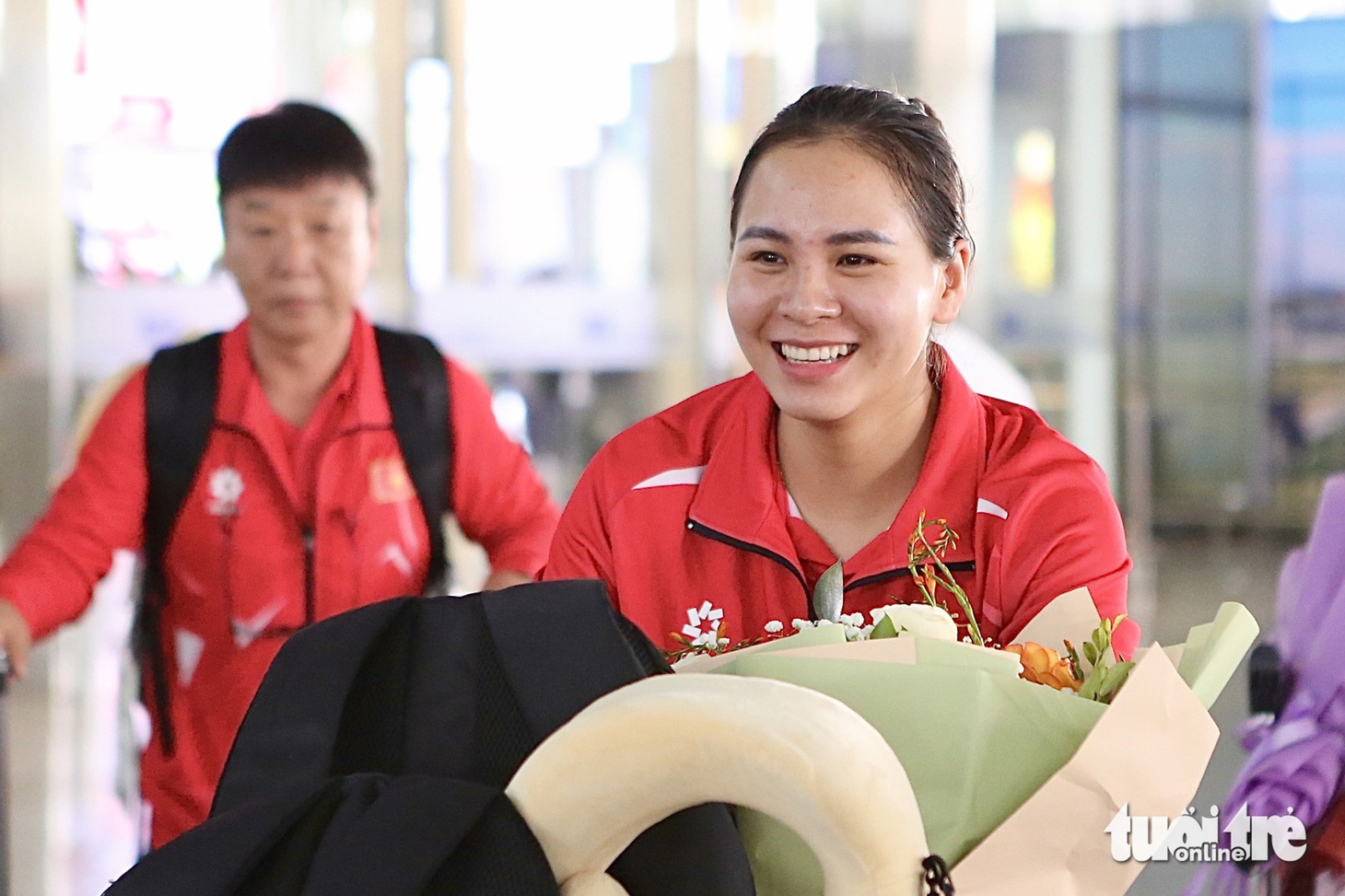 Nữ xạ thủ Trịnh Thu Vinh được một số khách chờ tại sân bay Nội Bài nhận ra. Tại Olympic Paris 2024, cô xếp hạng 4 nội dung 10m súng ngắn hơi nữ và hạng 7 nội dung 25m súng ngắn thể thao nữ - Ảnh: HOÀNG TÙNG