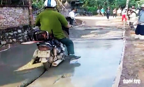 Bị ngăn cản vẫn thản nhiên đi xe máy vào đường đang đổ bêtông - Ảnh 2. Bị ngăn cản vẫn thản nhiên đi xe máy vào đường đang đổ bêtông - Ảnh 2.