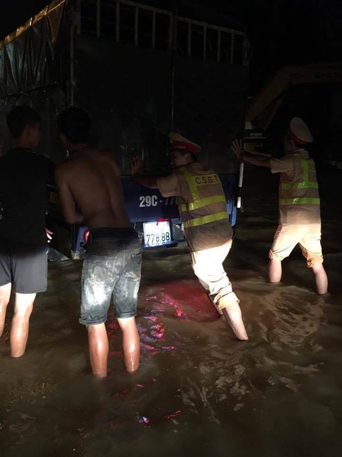 CSGT Hà Nội đẩy xe giúp dân qua vùng lũ trong đêm - Ảnh 1. CSGT Hà Nội đẩy xe giúp dân qua vùng lũ trong đêm - Ảnh 1.