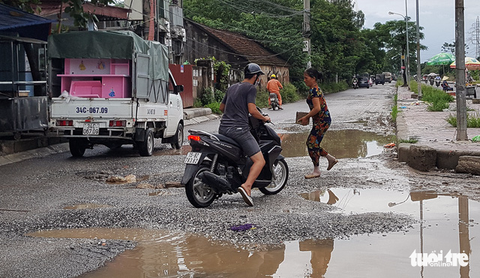 Đường 14 tỉ phập phều như bánh tráng, dân mang đá ra vá - Ảnh 1. Đường 14 tỉ phập phều như bánh tráng, dân mang đá ra vá - Ảnh 1.