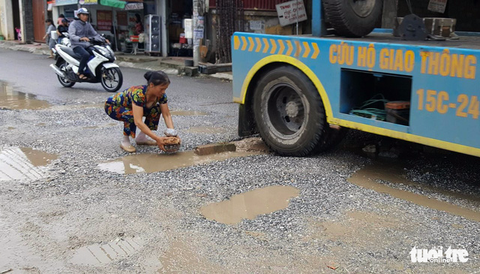 Đường 14 tỉ phập phều như bánh tráng, dân mang đá ra vá - Ảnh 2. Đường 14 tỉ phập phều như bánh tráng, dân mang đá ra vá - Ảnh 2.