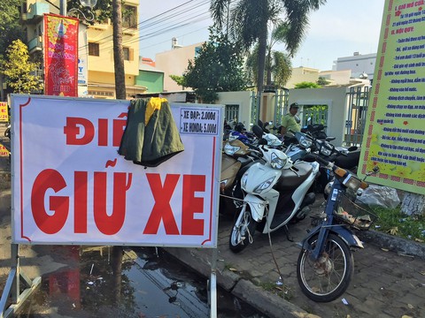 Lấy áo khoác trùm bảng giá giữ xe để thu quá giá - Ảnh 1. Lấy áo khoác trùm bảng giá giữ xe để thu quá giá - Ảnh 1.