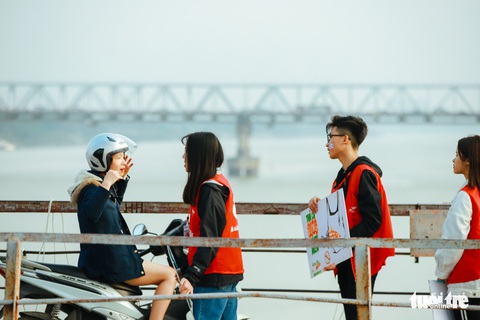 Chờ sẵn trên cầu, xin túi nilông của người thả cá chép - Ảnh 1. Chờ sẵn trên cầu, xin túi nilông của người thả cá chép - Ảnh 1.
