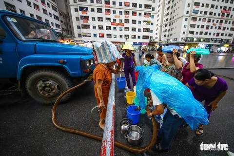 Người dân Hà Nội đội mưa hứng nước sạch - Ảnh 2. Người dân Hà Nội đội mưa hứng nước sạch - Ảnh 2.