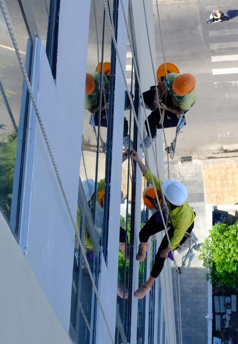 Cô gái treo mình lau kính trên các tòa nhà cao tầng như Người nhện - Ảnh 3. Cô gái treo mình lau kính trên các tòa nhà cao tầng như Người nhện - Ảnh 3.