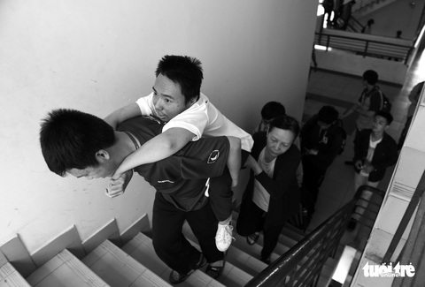 Người mẹ miệt mài cõng con bại liệt đến giảng đường đại học - Ảnh 1. Người mẹ miệt mài cõng con bại liệt đến giảng đường đại học - Ảnh 1.