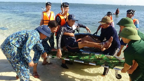 Cán bộ, chiến sỹ đưa ngư dân Long lên đảo để chữa trị - Ảnh: NGUYỄN NINH Cán bộ, chiến sỹ đưa ngư dân Long lên đảo để chữa trị - Ảnh: NGUYỄN NINH