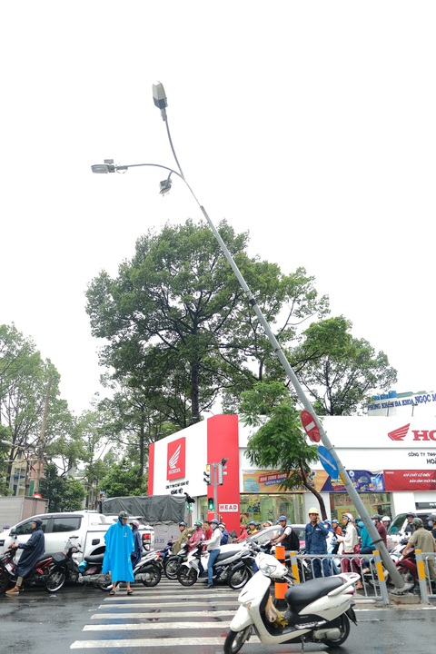 Kẹt xe do cột đèn bật gốc, nghiêng ngả giữa đường - Ảnh 1. Kẹt xe do cột đèn bật gốc, nghiêng ngả giữa đường - Ảnh 1.