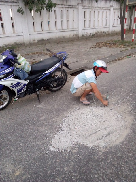 Hai thợ nề đục đẽo dẹp khối bêtông đổ giữa đường để xe không tai nạn - Ảnh 1. Hai thợ nề đục đẽo dẹp khối bêtông đổ giữa đường để xe không tai nạn - Ảnh 1.