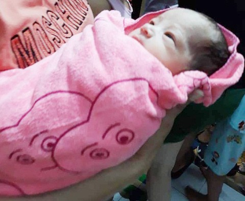 Tìm thấy bé sơ sinh trong túi nilông treo trên xe máy bên đường - Ảnh 1. Tìm thấy bé sơ sinh trong túi nilông treo trên xe máy bên đường - Ảnh 1.
