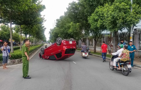 Xe hơi lật ngửa giữa đường, nữ hành khách nhập viện cấp cứu - Ảnh 1. Xe hơi lật ngửa giữa đường, nữ hành khách nhập viện cấp cứu - Ảnh 1.