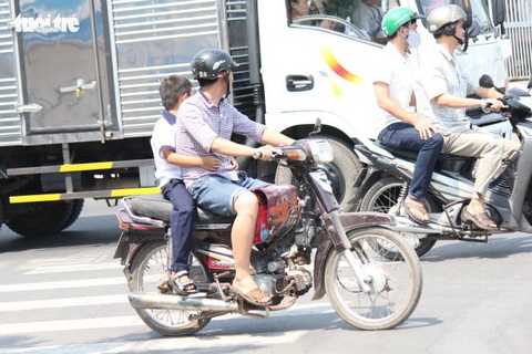 Chở trẻ em không đội mũ bảo hiểm bị phạt nghiêm từ tháng 9 - Ảnh 1. Chở trẻ em không đội mũ bảo hiểm bị phạt nghiêm từ tháng 9 - Ảnh 1.
