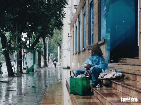 Mưa bão vẫn ráng mưu sinh ở Hà Nội - Ảnh 1. Mưa bão vẫn ráng mưu sinh ở Hà Nội - Ảnh 1.