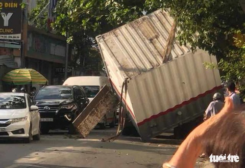 Vướng cây nghiêng, nguyên nhà vệ sinh di động rơi xuống đường - Ảnh 1. Vướng cây nghiêng, nguyên nhà vệ sinh di động rơi xuống đường - Ảnh 1.