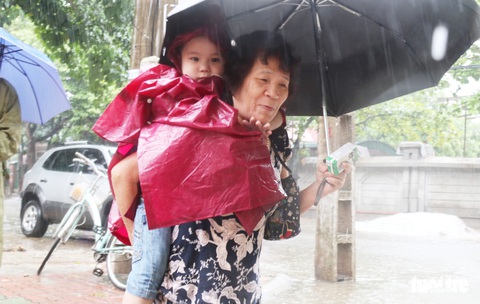 TP Vinh mưa xối xả ngập đường, phụ huynh vất vả đưa con đến trường - Ảnh 2. TP Vinh mưa xối xả ngập đường, phụ huynh vất vả đưa con đến trường - Ảnh 2.