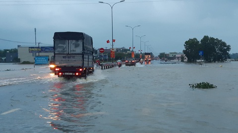 Nước lũ tràn qua quốc lộ 1 vào nhà dân, công an đội mưa điều tiết giao thông - Ảnh 2. Nước lũ tràn qua quốc lộ 1 vào nhà dân, công an đội mưa điều tiết giao thông - Ảnh 2.
