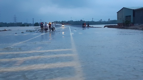 Nước lũ tràn qua quốc lộ 1 vào nhà dân, công an đội mưa điều tiết giao thông - Ảnh 4. Nước lũ tràn qua quốc lộ 1 vào nhà dân, công an đội mưa điều tiết giao thông - Ảnh 4.