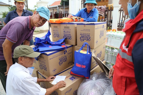 Bà con vùng lũ sẻ chia với nhau quà bạn đọc báo Tuổi Trẻ - Ảnh 2. Bà con vùng lũ sẻ chia với nhau quà bạn đọc báo Tuổi Trẻ - Ảnh 2.