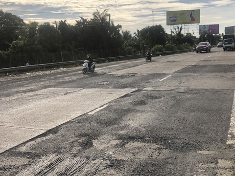 Quốc lộ 1 đoạn vào cầu Mỹ Thuận nứt nẻ và nhiều ổ gà - Ảnh 1. Quốc lộ 1 đoạn vào cầu Mỹ Thuận nứt nẻ và nhiều ổ gà - Ảnh 1.