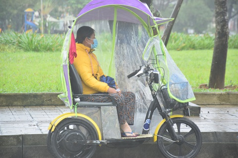 Những người già bán vé số đội mưa, co ro trong giá rét để mưu sinh - Ảnh 2. Những người già bán vé số đội mưa, co ro trong giá rét để mưu sinh - Ảnh 2.