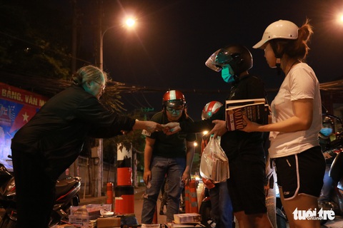 Bà cụ lom khom bán sách cũ lúc nửa đêm ở ngã tư Bảy Hiền - Ảnh 1. Bà cụ lom khom bán sách cũ lúc nửa đêm ở ngã tư Bảy Hiền - Ảnh 1.