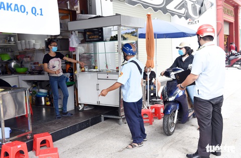 Quận 1 gõ cửa từng hộ vận động bán hàng mang về, nhắc đeo khẩu trang - Ảnh 1. Quận 1 gõ cửa từng hộ vận động bán hàng mang về, nhắc đeo khẩu trang - Ảnh 1.