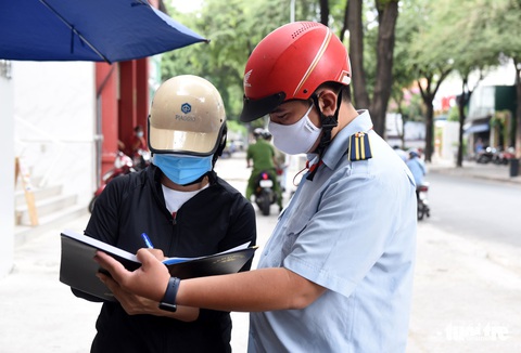 Quận 1 gõ cửa từng hộ vận động bán hàng mang về, nhắc đeo khẩu trang - Ảnh 3. Quận 1 gõ cửa từng hộ vận động bán hàng mang về, nhắc đeo khẩu trang - Ảnh 3.