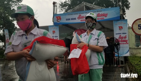 Mưa như trút, công nhân giúp nhau che hạt gạo sẻ chia kẻo ướt - Ảnh 3. Mưa như trút, công nhân giúp nhau che hạt gạo sẻ chia kẻo ướt - Ảnh 3.