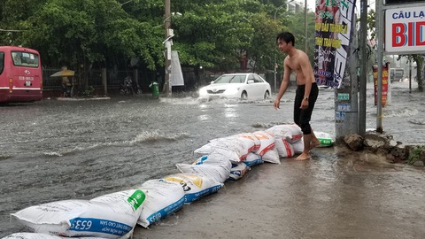 Mưa như trút nước, người dân lấy bao cát chắn nước tràn vào nhà - Ảnh 1. Mưa như trút nước, người dân lấy bao cát chắn nước tràn vào nhà - Ảnh 1.