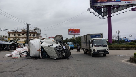 Xe container ôm cua lật ngang giữa bùng binh, tài xế thoát chết - Ảnh 1. Xe container ôm cua lật ngang giữa bùng binh, tài xế thoát chết - Ảnh 1.