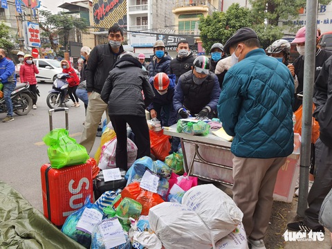 Người dân tranh thủ tiếp tế cho người thân trong khu vực phong tỏa - Ảnh 1. Người dân tranh thủ tiếp tế cho người thân trong khu vực phong tỏa - Ảnh 1.