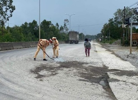 Cảnh sát giao thông dùng chổi, xẻng dọn dẹp đá dăm trên quốc lộ - Ảnh 1. Cảnh sát giao thông dùng chổi, xẻng dọn dẹp đá dăm trên quốc lộ - Ảnh 1.