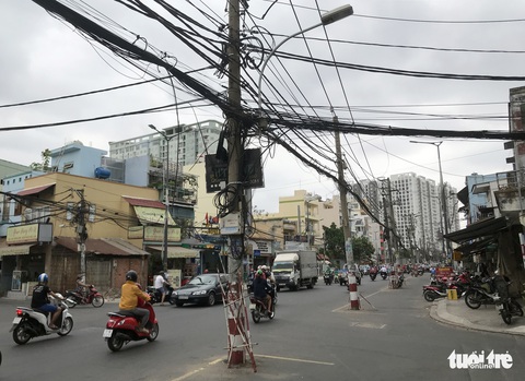 Hàng trụ điện giữa đường: Gỡ trụ, hạ dây một số đoạn - Ảnh 1. Hàng trụ điện giữa đường: Gỡ trụ, hạ dây một số đoạn - Ảnh 1.