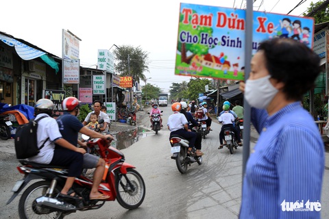 Bà ngoại Hai cầm bảng canh xe cho học trò qua đường an toàn - Ảnh 3. Bà ngoại Hai cầm bảng canh xe cho học trò qua đường an toàn - Ảnh 3.