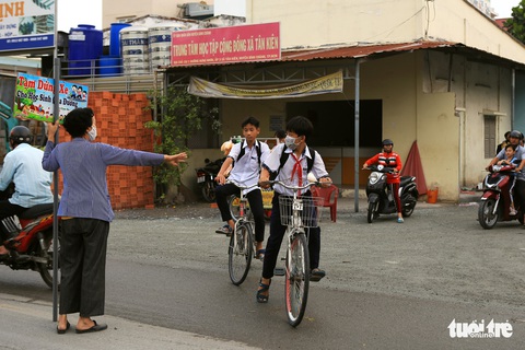 Bà ngoại Hai cầm bảng canh xe cho học trò qua đường an toàn - Ảnh 2. Bà ngoại Hai cầm bảng canh xe cho học trò qua đường an toàn - Ảnh 2.