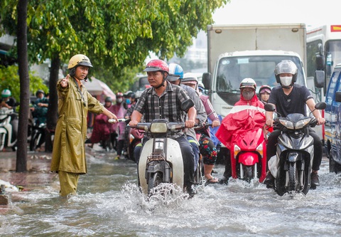 Đường Phạm Văn Đồng ngập, kẹt xe sau mưa lớn, CSGT phải moi rác cho nước chảy - Ảnh 3. Đường Phạm Văn Đồng ngập, kẹt xe sau mưa lớn, CSGT phải moi rác cho nước chảy - Ảnh 3.