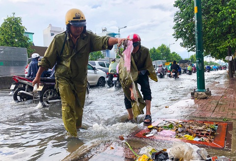 Đường Phạm Văn Đồng ngập, kẹt xe sau mưa lớn, CSGT phải moi rác cho nước chảy - Ảnh 1. Đường Phạm Văn Đồng ngập, kẹt xe sau mưa lớn, CSGT phải moi rác cho nước chảy - Ảnh 1.