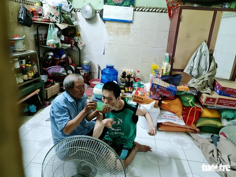 Người cha chạy xe ôm nuôi con bại não: ‘Dù thế nào thì nó vẫn là con tui’ - Ảnh 1. Người cha chạy xe ôm nuôi con bại não: ‘Dù thế nào thì nó vẫn là con tui’ - Ảnh 1.