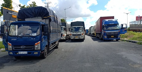 Hàng chục xe chở hàng thiết yếu bị kẹt tại chốt do quy định phải xuống hàng sang xe - Ảnh 1. Hàng chục xe chở hàng thiết yếu bị kẹt tại chốt do quy định phải xuống hàng sang xe - Ảnh 1.