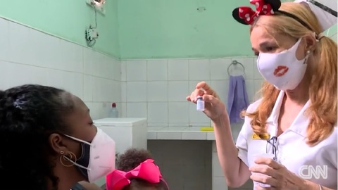 Y bác sĩ Cuba đeo băng đô chuột Mickey khi chích ngừa cho trẻ - Ảnh 1. Y bác sĩ Cuba đeo băng đô chuột Mickey khi chích ngừa cho trẻ - Ảnh 1.