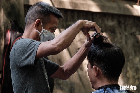 Tiệm cắt tóc vỉa hè, salon tóc đông kín khách ngày đầu mở lại - Ảnh 1. Tiệm cắt tóc vỉa hè, salon tóc đông kín khách ngày đầu mở lại - Ảnh 1.