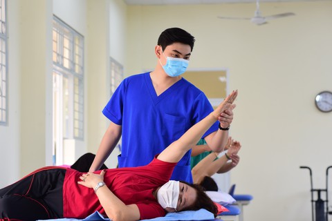 Tin tức sáng 19-7: Điểm chất lượng bệnh viện tư TP.HCM cao hơn công lập; Cảnh báo lừa tuyển mẫu nhí - Ảnh 2. Hướng dẫn tập phục hồi chức năng tại Bệnh viện Lê Văn Thịnh - Ảnh: DUYÊN PHAN