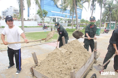 Dân Đà Nẵng kéo ra biển dọn cát lấp, bèo dạt sau bão - Ảnh 4. Dân Đà Nẵng kéo ra biển dọn cát lấp, bèo dạt sau bão - Ảnh 4.
