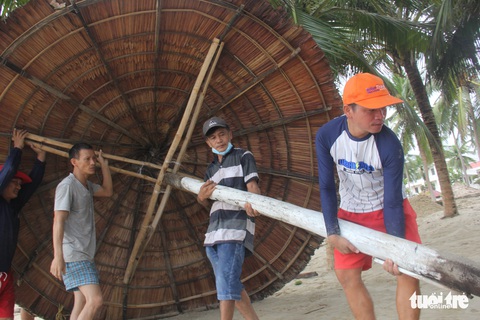 Dân Đà Nẵng kéo ra biển dọn cát lấp, bèo dạt sau bão - Ảnh 1. Dân Đà Nẵng kéo ra biển dọn cát lấp, bèo dạt sau bão - Ảnh 1.