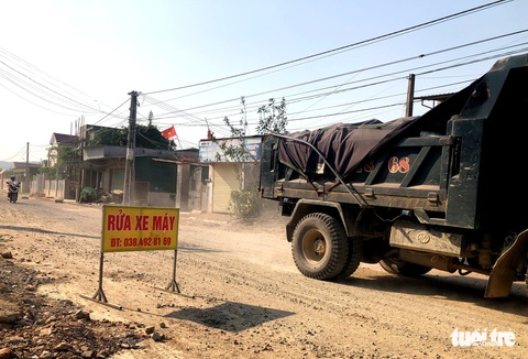 Người dân dùng đá, xe kéo chắn ngang vì đường trăm tỉ đang làm quá bụi - Ảnh 1. Người dân dùng đá, xe kéo chắn ngang vì đường trăm tỉ đang làm quá bụi - Ảnh 1.