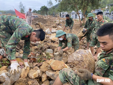 Bới đá, gạn đất tìm lại phần mộ cho dân vùng lũ - Ảnh 1. Bới đá, gạn đất tìm lại phần mộ cho dân vùng lũ - Ảnh 1.