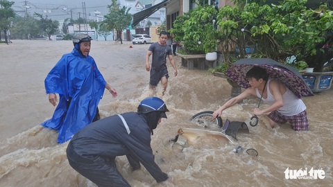 Mưa lớn kéo dài tại Quy Nhơn, xe máy và người đi đường bị nước cuốn - Ảnh 1. Mưa lớn kéo dài tại Quy Nhơn, xe máy và người đi đường bị nước cuốn - Ảnh 1.