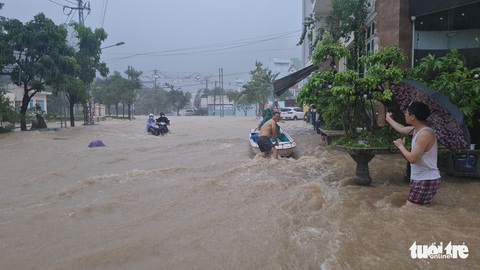Mưa lớn kéo dài tại Quy Nhơn, xe máy và người đi đường bị nước cuốn - Ảnh 2. Mưa lớn kéo dài tại Quy Nhơn, xe máy và người đi đường bị nước cuốn - Ảnh 2.
