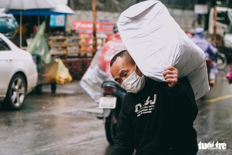 Người lao động ở Hà Nội trùm áo mưa, đốt lửa chống rét để mưu sinh - Ảnh 9. Người lao động ở Hà Nội trùm áo mưa, đốt lửa chống rét để mưu sinh - Ảnh 9.
